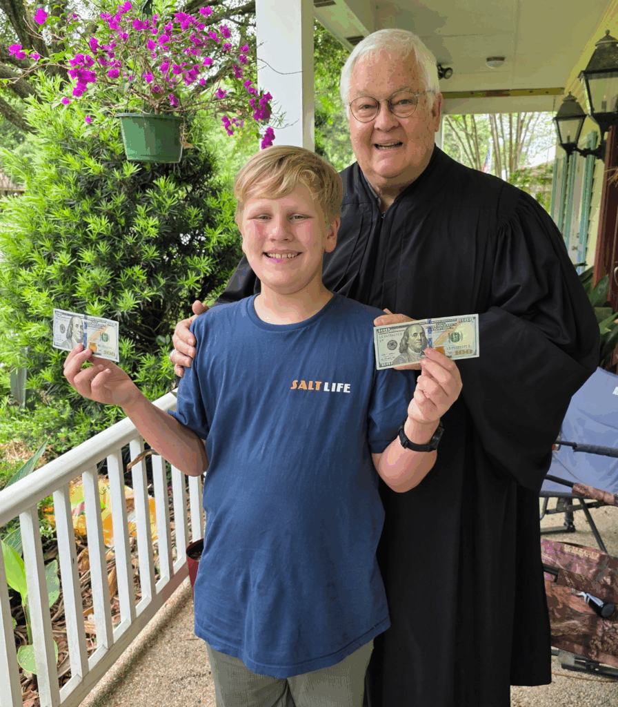 Asher stands next to Retired Judge Darrell White to receive a monetary prize for his efforts.